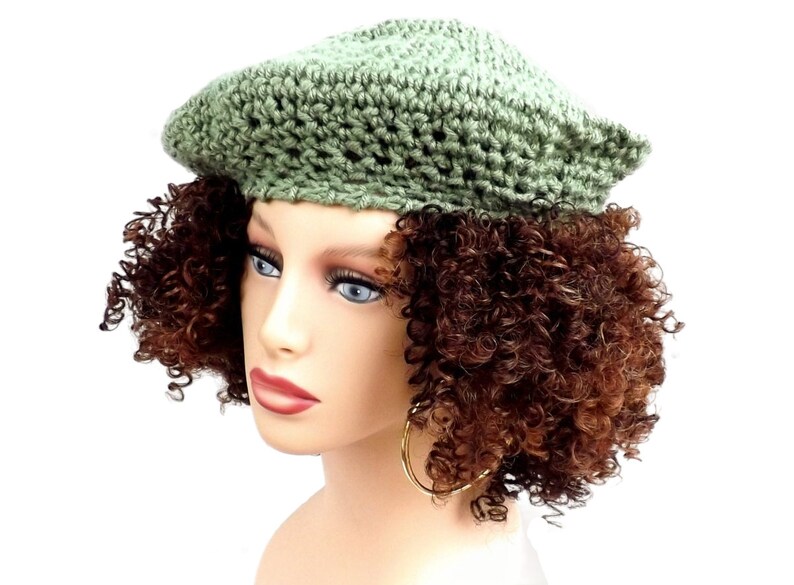 a mannequin head wearing a green crochet hat