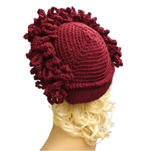 a mannequin head wearing a burgundy crocheted hat