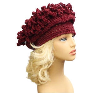 a mannequin head wearing a burgundy crocheted hat