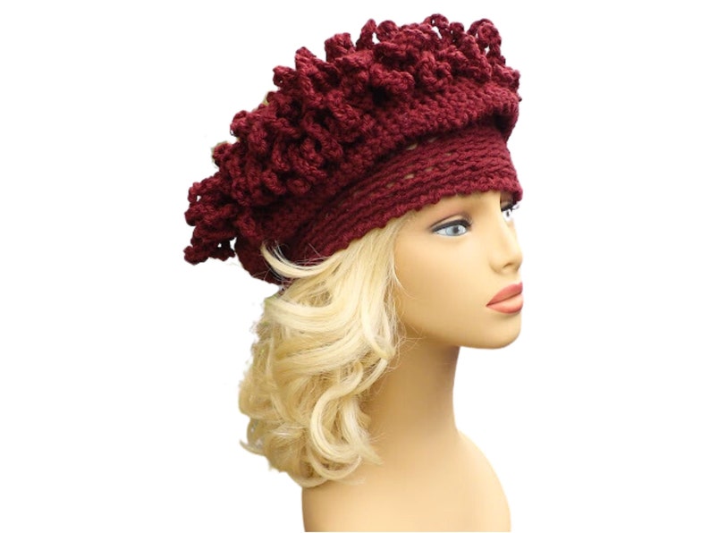 a mannequin head wearing a burgundy crocheted hat