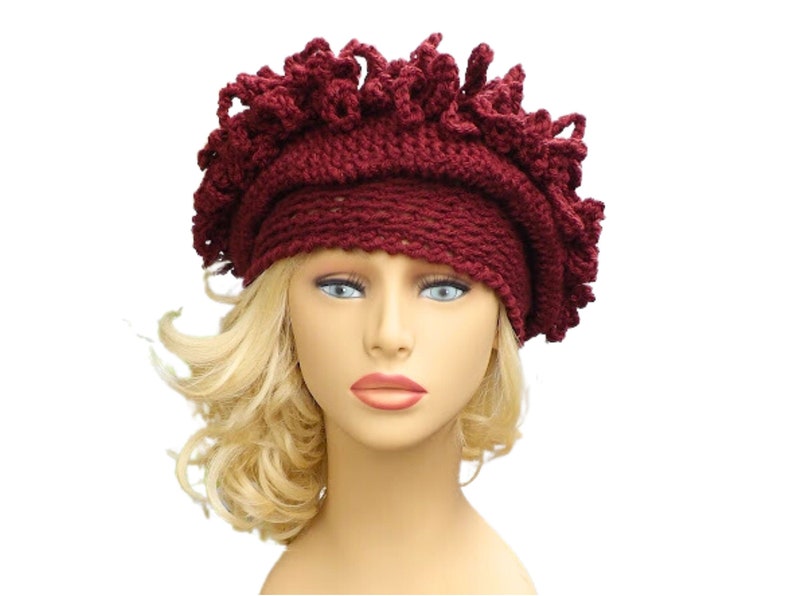 a mannequin head wearing a burgundy crocheted hat