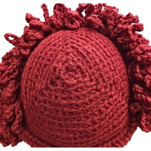 a crocheted burgundy red hat with a fringe on it