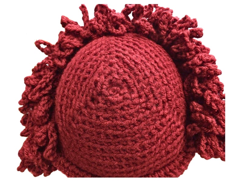 a crocheted burgundy red hat with a fringe on it