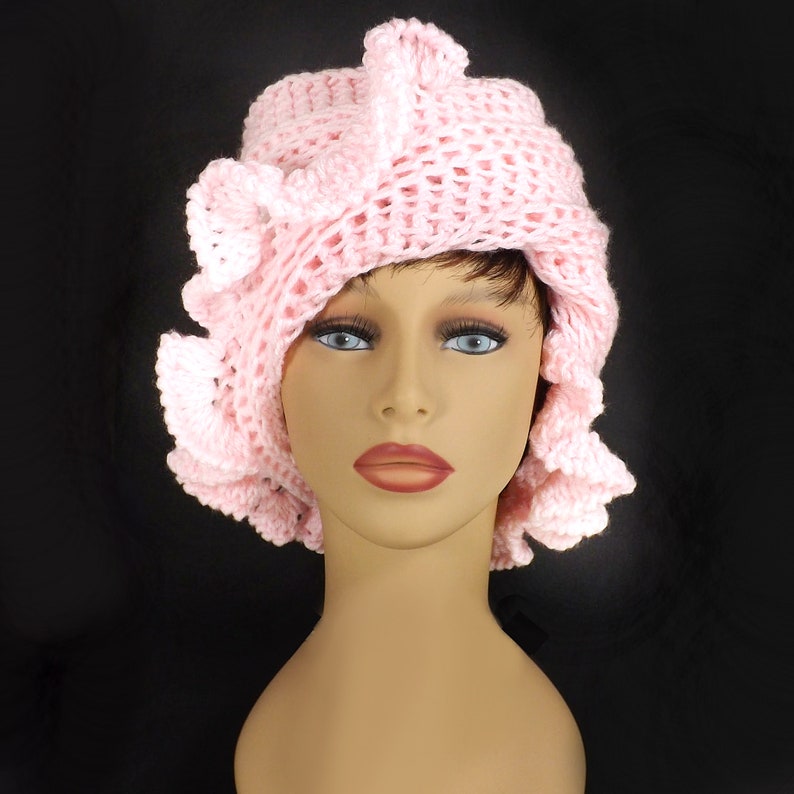 a crocheted hat with a ruffle on a mannequin head