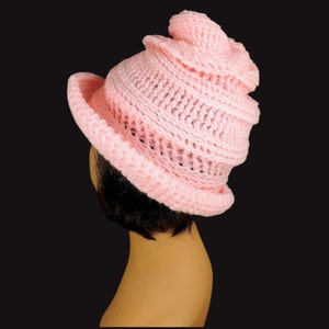 Top view of a mannequin head donning a pink Virginia Mobius strip crocheted cloche hat pattern, emphasizing the twisted pattern and snug fit