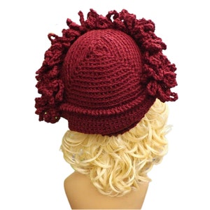 a mannequin head wearing a burgundy crocheted hat