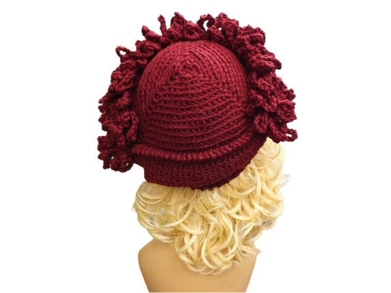 a mannequin head wearing a burgundy crocheted hat