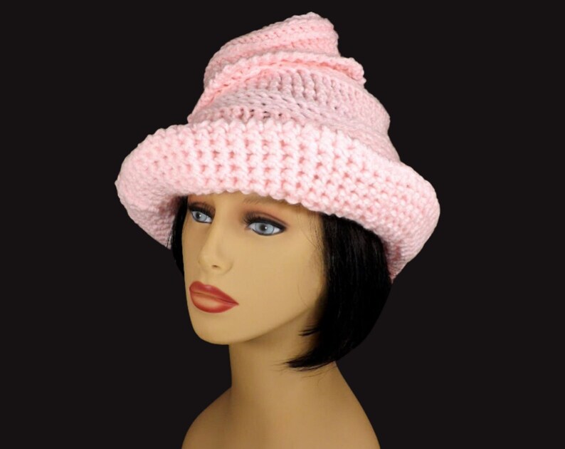 Back angle view of a pastel pink Virginia Mobius crochet cloche hat pattern worn on a mannequin, displaying the hat's intricate Mobius strip design