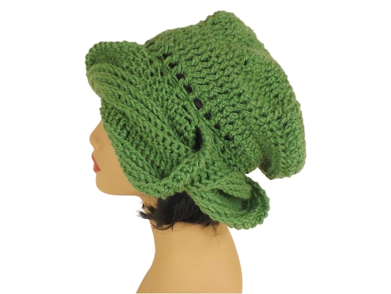 Unique Möbius Crochet Hat Pattern - Samantha Slouchy Beanie with Twist Brim. A green knit slouchy beanie hat modeled on a mannequin head, showing the side view. The hat has an unusual twisted, wrapped style to the brim.