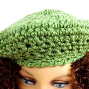 a close up of a mannequin head wearing a green crochet hat