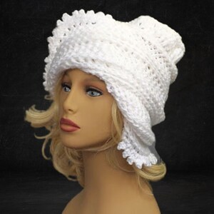 Three-quarter view of a mannequin head donning a white 1960s Lisa design Mobius crochet hat, exuding timeless elegance with its intricate pattern and flapper style