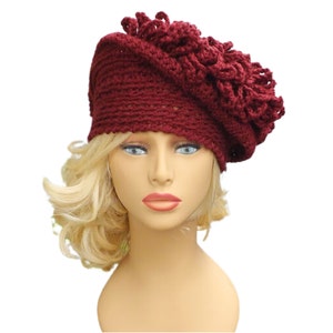 a mannequin head wearing a burgundy crocheted hat