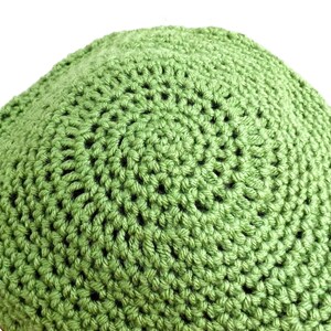 a green crocheted hat is shown on a white background