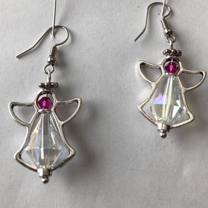May include: A pair of silver angel earrings with clear iridescent crystal accents and pink beads.