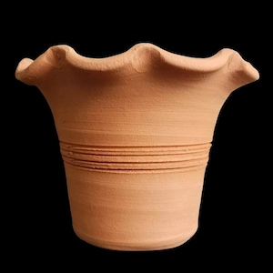 May include: A terracotta flower pot with a scalloped rim and a decorative band of lines around the middle.