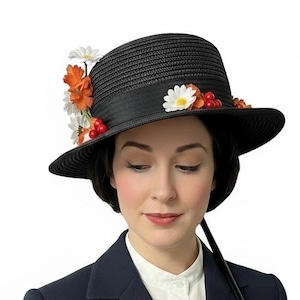Può includere: Un cappello di paglia nero con tesa larga e un nastro nero. Il cappello è decorato con fiori di margherita bianchi, fiori arancioni e piccole bacche rosse disposte lungo il lato e la parte anteriore della corona, creando un accento floreale.