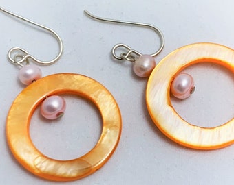 Glanzende oranje schaal bungelt met lichtroze zoetwaterparels en sterling zilver