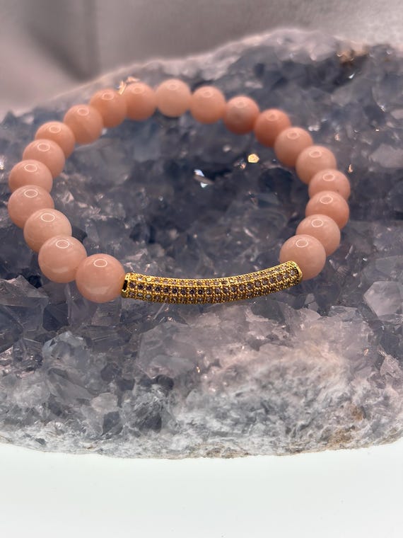 Energetically NURTURING pale peach jade beads complimenting cubic zirconia pave gold plated noodle focal bead stretch bracelet