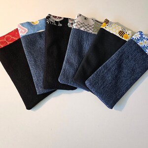 May include: Six fabric eyeglass cases with denim and black fabric bodies. Each case has a patterned top border in red, blue, black, gray, yellow, and blue. Patterns include hearts, cats, owls, bees, and daisies.