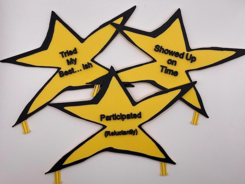 May include: Three yellow star-shaped decorations with black outlines and black text. The stars feature the phrases "Tried My Best... ish", "Showed Up on Time", and "Participated (Reluctantly)". Each star has a small yellow tab at the bottom.