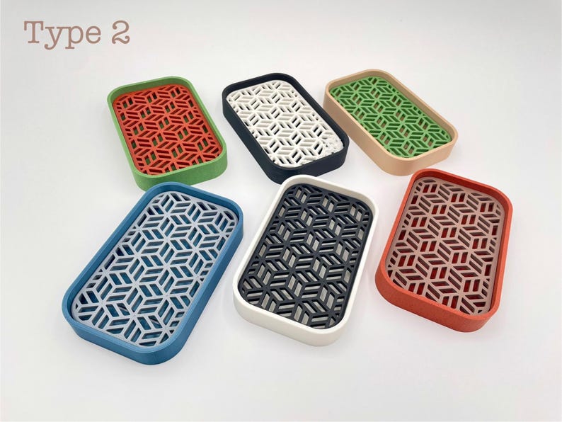 May include: Rectangular trays in various colors, including red, green, blue, and black, with a geometric pattern. The trays have a raised border and a patterned interior. The text "Type 2" is in the upper left corner.