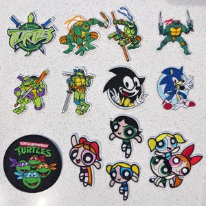 Apliques bordados retrô de personagens de desenhos animados: Tartarugas Ninja, Super-heroínas, Ouriço Azul. Apliques termocolantes fofos para jaquetas e mochilas.