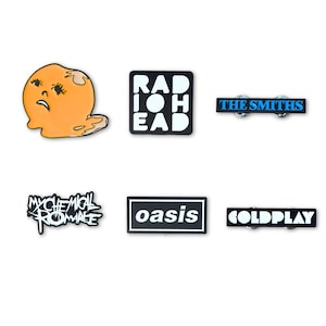 Op de afbeelding: Een verzameling van zes emaille pins met verschillende bandlogo's en ontwerpen. Inbegrepen zijn een smeltend oranje gezicht, een vierkant Radiohead-logo, een rechthoekige The Smiths-pin, een My Chemical Romance-logo, een Oasis-rechthoek en een Coldplay-pin.