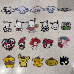 May include: A collection of twenty embroidered patches featuring various Sanrio characters including Cinnamoroll, Pochacco, Keroppi, My Melody, Pompompurin, and Badtz-Maru. Each patch displays distinct character poses, expressions, and colorful details.