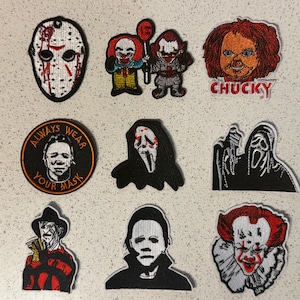 May include: A collection of embroidered patches featuring horror movie characters. Includes Jason Voorhees' mask, Pennywise the clown, Chucky, and Michael Myers. One patch reads "ALWAYS WEAR YOUR MASK".
