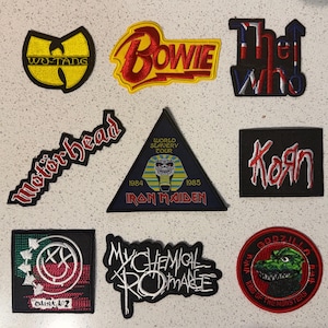 Può includere: Una collezione di toppe ricamate con vari loghi e disegni di band. Include toppe per Wu-Tang, Bowie, The Who, Motörhead, Iron Maiden, Korn, Blink 182, My Chemical Romance e Godzilla.