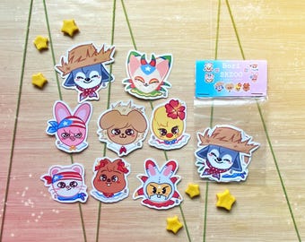 Op de afbeelding: Een verzameling kleurrijke stickers met cartoon-dierenfiguren met diverse accessoires. De stickers bevatten een blauwe hond met een strohoed, een roze konijn met een hoofdband en een gele kuiken met een bloem.