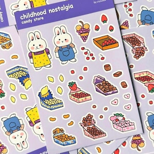 May include: Sticker sheets with a purple background, featuring cartoon bunnies, sweets, and fruit illustrations. The text "childhood nostalgia candy store" is visible. Stickers include strawberries, grapes, and chocolates.