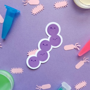 May include: A purple sticker of a chain of cute cartoon bacteria with smiling faces. The sticker is on a purple background with other pink bacteria stickers.