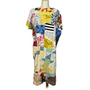 May include: A patchwork dress with a variety of fabric patterns and colors, including floral, polka dot, and striped designs. The dress has short sleeves and a loose fit, showcasing a unique, handcrafted aesthetic.