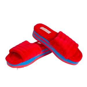 May include: Red fuzzy slippers with a blue and red platform sole.