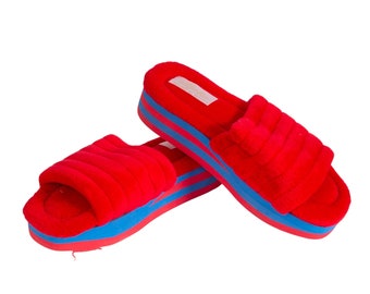 Puede incluir: Pantuflas rojas peludas con suela de plataforma azul y roja.