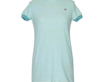 May include: A short-sleeved mini dress featuring a horizontal striped pattern in light blue and white. The garment has a solid light blue crew neckline and matching sleeve cuffs. A small, circular embroidered emblem is located on the upper left chest.