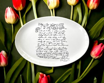 May include: A white ceramic oval serving dish with handwritten instructions for preparing turkey giblets. The dish is surrounded by red flowers.