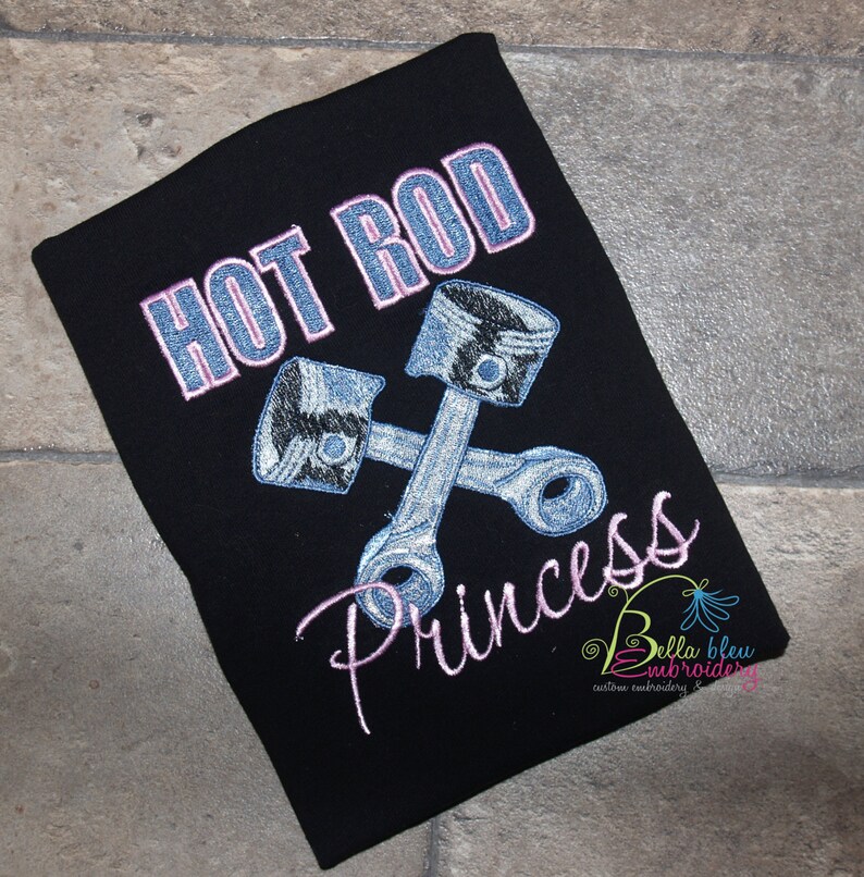 May include: Black t-shirt with pink embroidery that says "Hot Rod Princess". The design includes two crossed silver engine pistons.