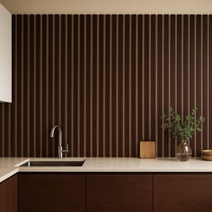 May include: Modern kitchen design featuring dark brown wood cabinetry and a matching vertical slat wall. A stainless steel faucet and sink are set into a light-colored countertop. Decorative elements include a small wooden cutting board, a glass vase with greenery, and two wooden bowls.