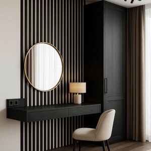 Pu&ograve; includere: Un moderno set da toeletta con una scrivania nera sospesa, uno specchio rotondo con cornice dorata e una sedia imbottita beige. La parete presenta pannelli verticali bianchi e neri e una piccola lampada &egrave; sulla scrivania.