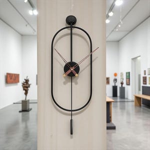 Könnte beinhalten: Schwarze Metall-Wanduhr mit ovalem Rahmen und Pendel. Das Zifferblatt ist schwarz mit braunen Zeigern und goldenen Akzenten. Die Uhr ist an einer hellen Wand in einer Galerie befestigt.