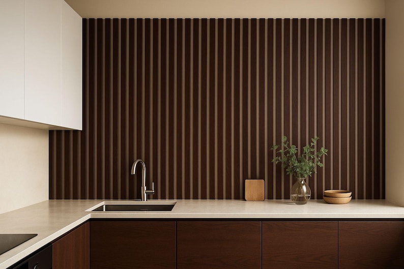 May include: Modern kitchen design featuring dark brown wood cabinetry and a matching vertical slat wall. A stainless steel faucet and sink are set into a light-colored countertop. Decorative elements include a small wooden cutting board, a glass vase with greenery, and two wooden bowls.