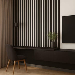 May include: Modern interior design featuring a black desk with drawers, a black chair, and a wall with vertical black and white stripes. A black television is mounted on the wall. The room has hardwood floors and a neutral-colored rug.