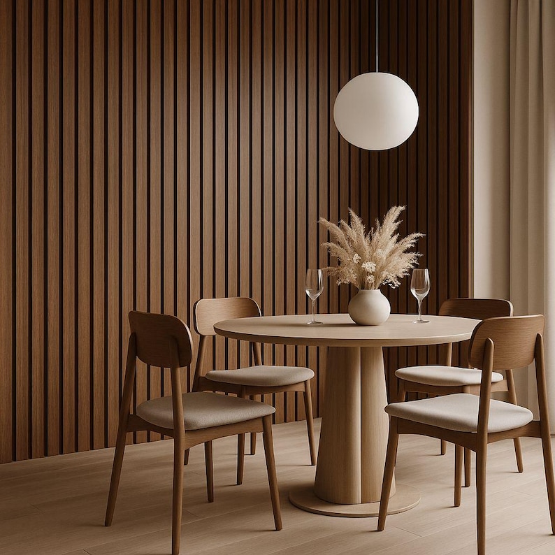 Pu&ograve; includere: Una sala da pranzo moderna con un tavolo rotondo in legno, quattro sedie e un vaso decorativo con fiori secchi. Una grande lampada a sospensione rotonda &egrave; appesa sopra il tavolo. Le pareti sono rivestite con doghe di legno verticali.