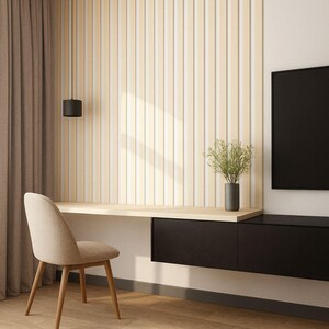 May include: Modern home office setup featuring a light wood desk, a beige chair, and a black storage unit. The wall has vertical wooden panels. A black pendant light hangs above the desk, and a vase with greenery sits on the desk.