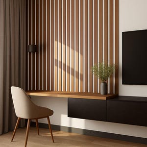 May include: Modern home office setup featuring a wooden desk with black drawers, a beige chair, and a decorative wooden wall panel. A black TV is mounted on the wall. The room has hardwood floors and a neutral color palette.