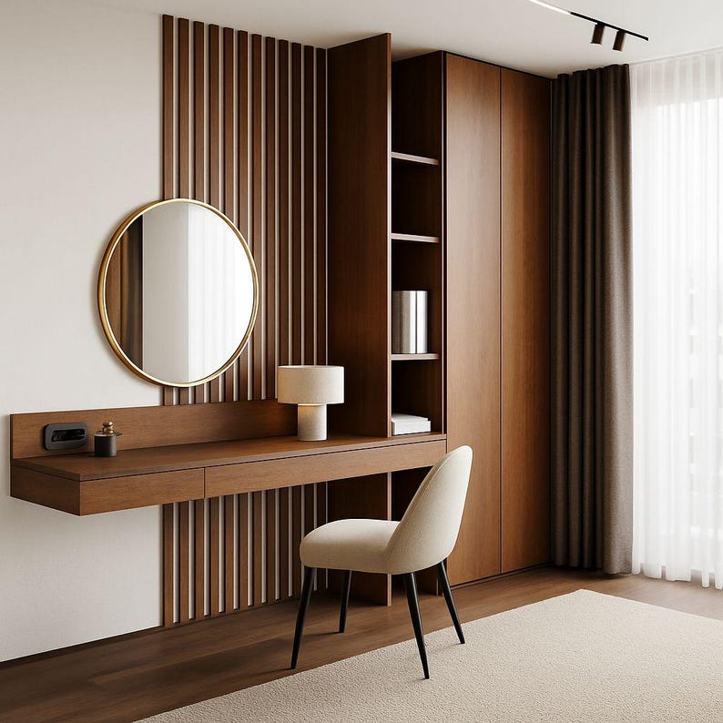 Pu&ograve; includere: Un moderno set da toeletta con una scrivania sospesa in legno, uno specchio rotondo con cornice dorata e una sedia beige. La scrivania ha un cassetto integrato e una piccola lampada. Lo sfondo presenta una parete a pannelli di legno e un'alta credenza in legno.