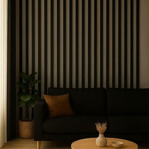 May include: A modern living room with a black sofa, brown throw pillow, and a round wooden coffee table. A decorative wall with vertical black slats is behind the sofa. A potted plant and a beige rug complete the scene.