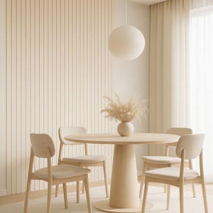 Pu&ograve; includere: Un tavolo da pranzo rotondo in legno chiaro con quattro sedie abbinate. Un vaso di fiori secchi &egrave; sul tavolo. La stanza ha una palette di colori neutri con una grande lampada rotonda e una parete a pannelli verticali.